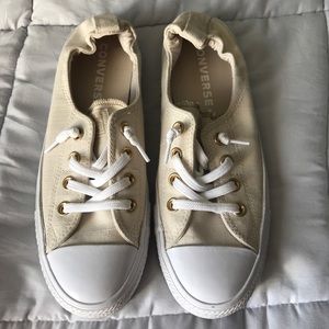 A pair of cream colored low converse.